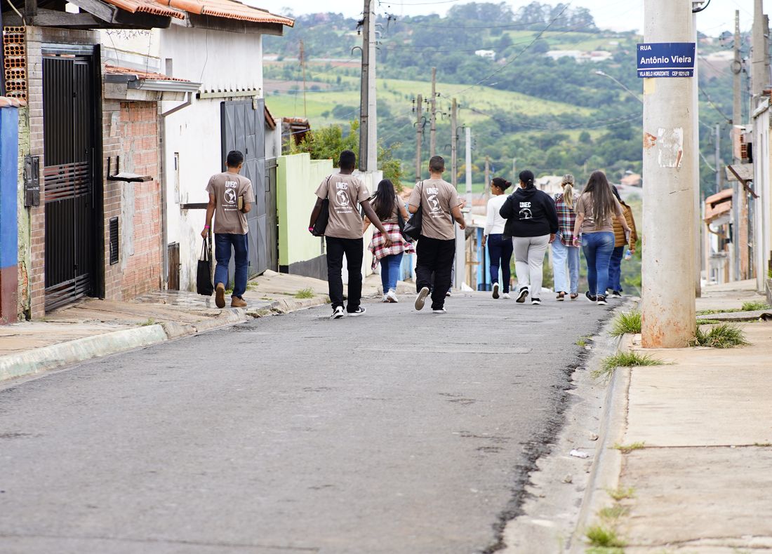 Equipe da UNEC Paulista caminhando pela rua de um bairro durante o avanço em Itapetininga